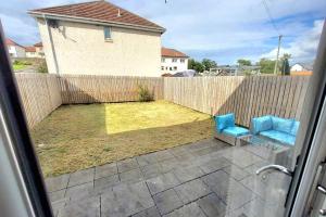 a patio with two blue chairs and a fence at Three Bedrooms House By Sensational Stay Short Lets & Serviced Accommodation With Free Parking & Wi-fi in Ballingry