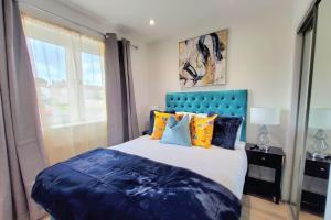 Three Bedrooms House By Sensational Stay Short Lets & Serviced Accommodation With Free Parking & Wi-fi في Ballingry: غرفة نوم مع سرير كبير مع اللوح الأمامي الأزرق