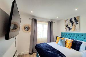 a bedroom with a bed with a blue head board at Three Bedrooms House By Sensational Stay Short Lets & Serviced Accommodation With Free Parking & Wi-fi in Ballingry