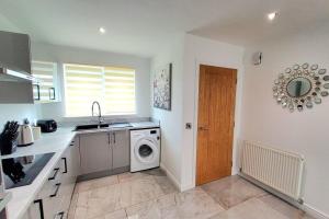 a kitchen with a washing machine and a sink at Three Bedrooms House By Sensational Stay Short Lets & Serviced Accommodation With Free Parking & Wi-fi in Ballingry