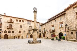 a stone building with a clock tower in a courtyard at Hotel Villa de Cretas in Cretas