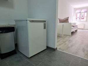 einen weißen Kühlschrank in einem Zimmer mit einem Schlafzimmer in der Unterkunft Ferienwohnung in historischer Altstadt - Wertheim in Wertheim