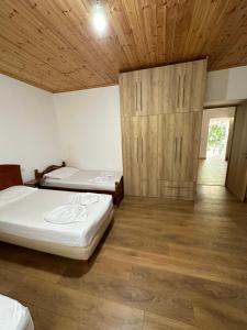 1 Schlafzimmer mit 2 Betten und Holzdecke in der Unterkunft progon house in Tepelenë