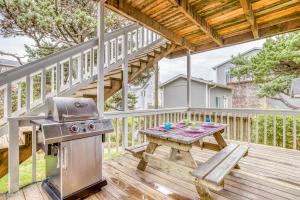 a patio with a grill and a picnic table on a deck at Sea-Renity in Lincoln City