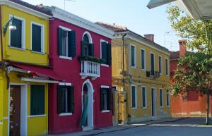 a row of colorful houses on a street at Casa degli Artisti in Burano