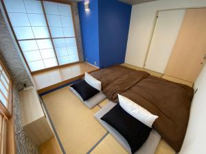 Habitación pequeña con 2 camas y ventana en 日月庵 BnB Sunmoon, en Kanazawa