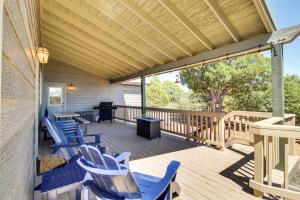 una terraza de madera con sillas azules y una mesa en Secluded Show Low Home Near Hiking Trails!, en Show Low