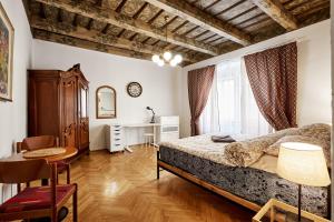 a bedroom with a bed and a table and a window at At the Blue Lion & Parking Assistance in Prague