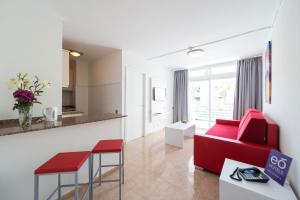 普拉亞戴爾雷安格萊斯的住宿－EO拉斯羅薩斯公寓，一间带红色沙发的客厅和一间厨房