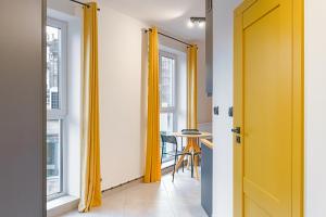a hallway with yellow drapes and a table at Loft deLUX in Bielsko-Biała