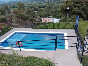 una piscina con una valla de metal alrededor en La Mejor Casa Campestre con vista cerca al Parque del Café, en Pueblo Tapado