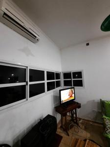 sala de estar con TV y algunas ventanas en La Lechuzona- Country Rincon SantaMaria en Ituzaingó