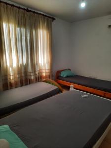 una habitación con dos camas y una ventana en La Lechuzona- Country Rincon SantaMaria, en Ituzaingó