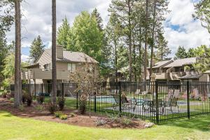 une clôture noire devant une maison avec une cour dans l'établissement Fairway Village 12, à Sunriver