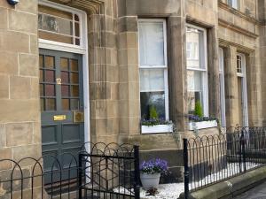 a building with a blue door and two windows at Lovely main door 2 bed apartment in Edinburgh