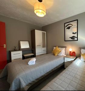 a bedroom with a large bed and a desk at Orchard House - Suitable for both Family and Business Travellers, Walk in distance to pubs, restaurants, Supermarket, Free Wifi & Free Parking, Outdoor Garden in Swindon