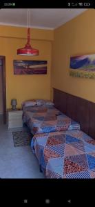 una habitación con 4 camas alineadas contra una pared en CASA MORENO VUT, en Ávila