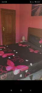 Un dormitorio con una cama con flores rosas. en CASA MORENO VUT, en Ávila
