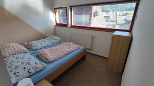 a small room with two beds and a window at Rodinný Apartmán Adléta in Horní Bečva