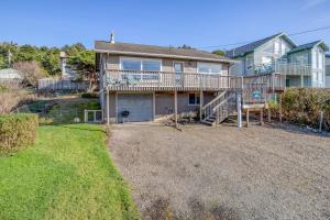 a large house with a deck and a yard at A Sea Breeze in Lincoln City