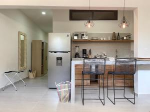 uma cozinha com um frigorífico e algumas cadeiras em Rooms Huatulco em Santa Cruz, Huatulco