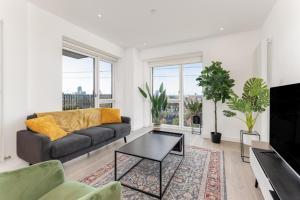 a living room with a couch and a table at Docklands Two Bed Apartment in London