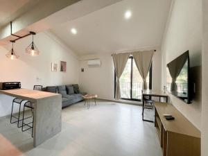 uma cozinha e sala de estar com um sofá e uma mesa em Rooms Huatulco em Santa Cruz, Huatulco