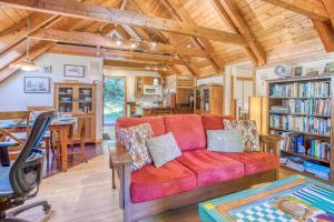 un soggiorno e una sala da pranzo con un divano rosso di Guineveres Cottage a Yachats