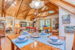 a dining room and living room with a wooden ceiling at Guinevere's Cottage in Yachats