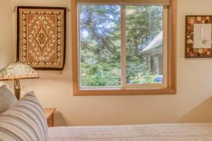 a bedroom with a bed and a window at Guinevere's Cottage in Yachats