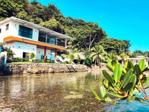 una casa en la orilla de un cuerpo de agua en Kasakai Beachouse en Juan Gallego