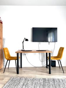 een bureau met een computer en 2 stoelen in een kamer bij George Studio przy Stadionie Narodowym in Warschau