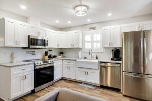 uma cozinha com armários brancos e electrodomésticos de aço inoxidável em Step-Free Home with Fire Pit - 3 Miles to USC! em Columbia