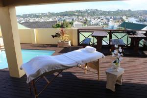 Bett auf einer Terrasse mit Poolblick in der Unterkunft Royal Guest House in Port Alfred