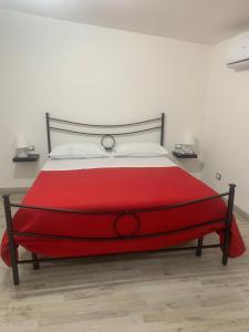 a red bed in a bedroom with a white wall at Loft Home Sweet Home in Catania