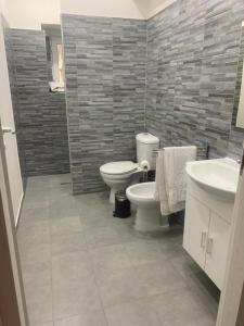 a bathroom with two toilets and a sink at Loft Home Sweet Home in Catania