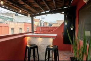 dos taburetes negros sentados en un balcón con ventana en La Casa de Maria, Downtown with AC & Free Parking en San Miguel de Allende