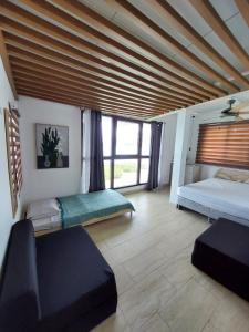 1 dormitorio con 2 camas y ventana grande en Kasakai Beachouse en Juan Gallego
