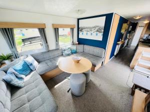 a living room with a couch and a table at 3 Bedroom Caravan RW75, Thorness Bay, Dog Friendly, WiFi in Porchfield