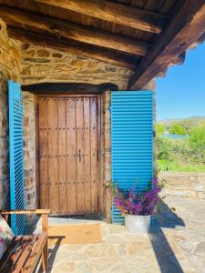 a wooden door of a house with blue shutters at Casa La Rocita in Badajoz