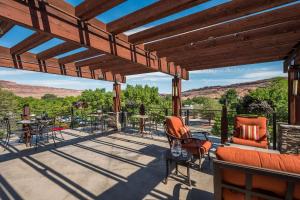 een terras met stoelen en uitzicht op de bergen bij Best Western Plus Canyonlands Inn in Moab
