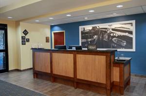 a lobby with a reception desk and a car on the wall at Hampton Inn Winfield in Tucker