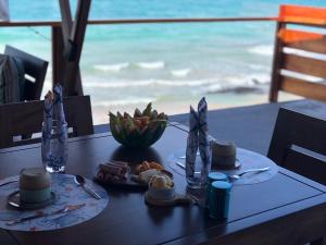 una mesa con dos platos de comida y la playa en Cormorant Beach House, en Puerto Villamil