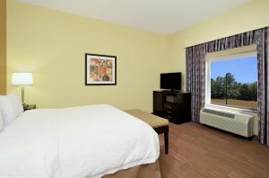 a hotel room with a bed and a window at Hampton Inn Winfield in Tucker