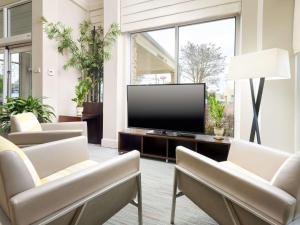 a living room with a flat screen tv and chairs at Hilton Garden Inn Chattanooga/Hamilton Place in Chattanooga