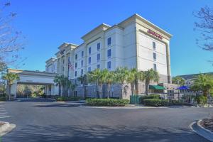 a hotel with palm trees in front of a building at Hampton Inn Jacksonville - East Regency Square in Jacksonville