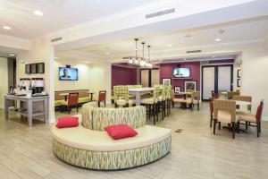 a lobby with a waiting room with tables and chairs at Hampton Inn Jacksonville - East Regency Square in Jacksonville