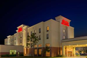 un edificio de hotel con un letrero de neón en él en Hampton Inn & Suites Oklahoma City - South, en Oklahoma City