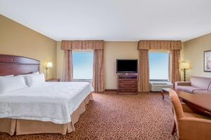 a hotel room with a bed and a couch and a television at Hampton Inn & Suites Oklahoma City - South in Oklahoma City