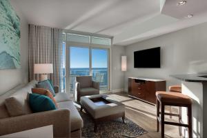 a living room with a couch and a tv at Hilton Grand Vacations Club Ocean 22 Myrtle Beach in Myrtle Beach